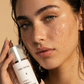 Woman holding a skincare product with a neutral background
